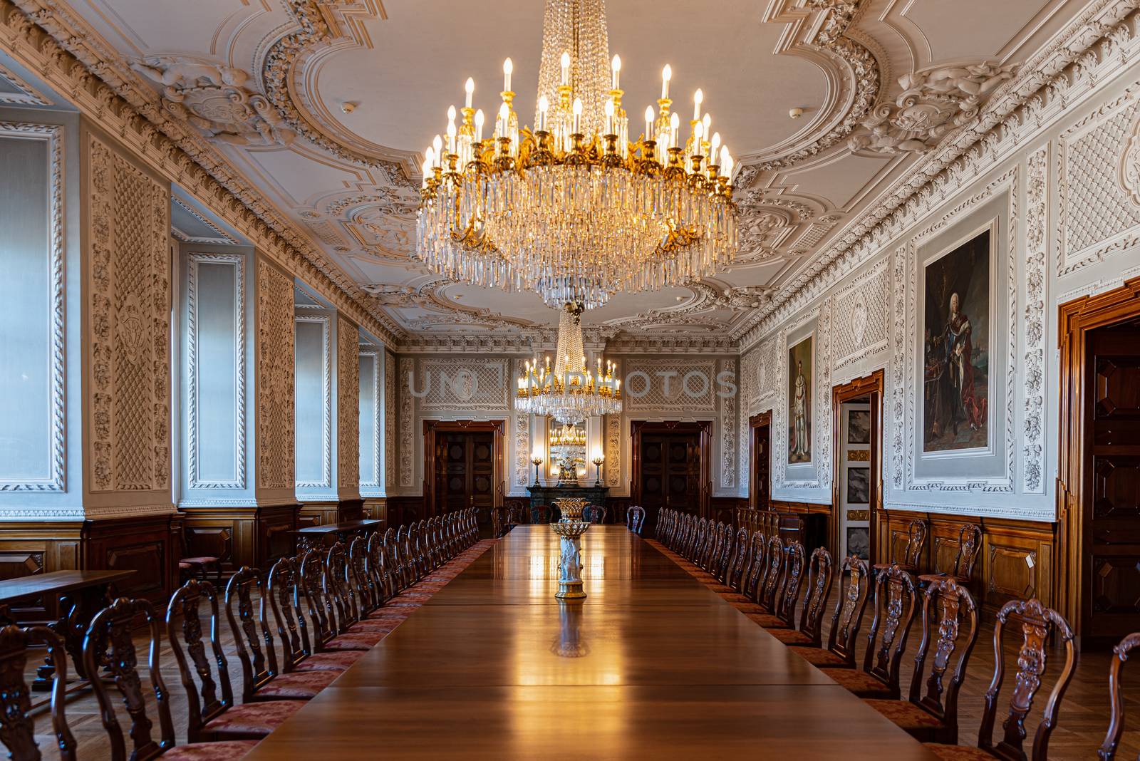 Large antique wooden table under a crystal chandelier in a historic hall of a royal palace in Copenhagen, Denmark