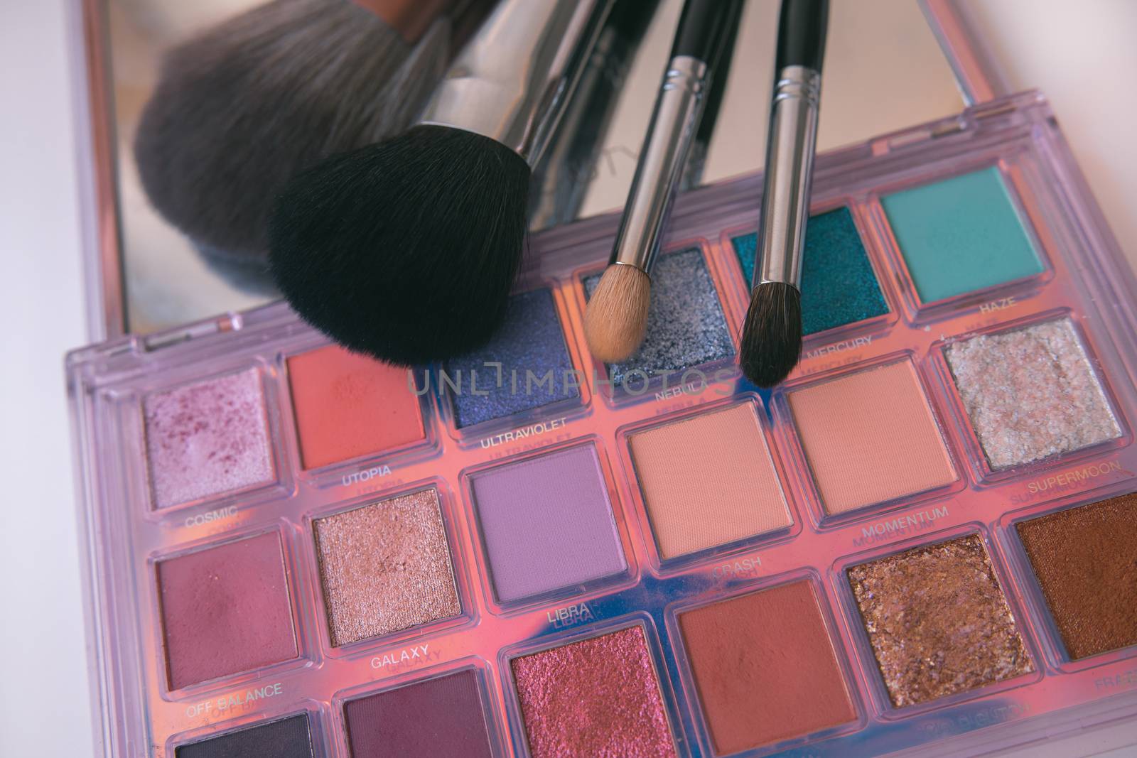 Makeup brushes and color palete on white background