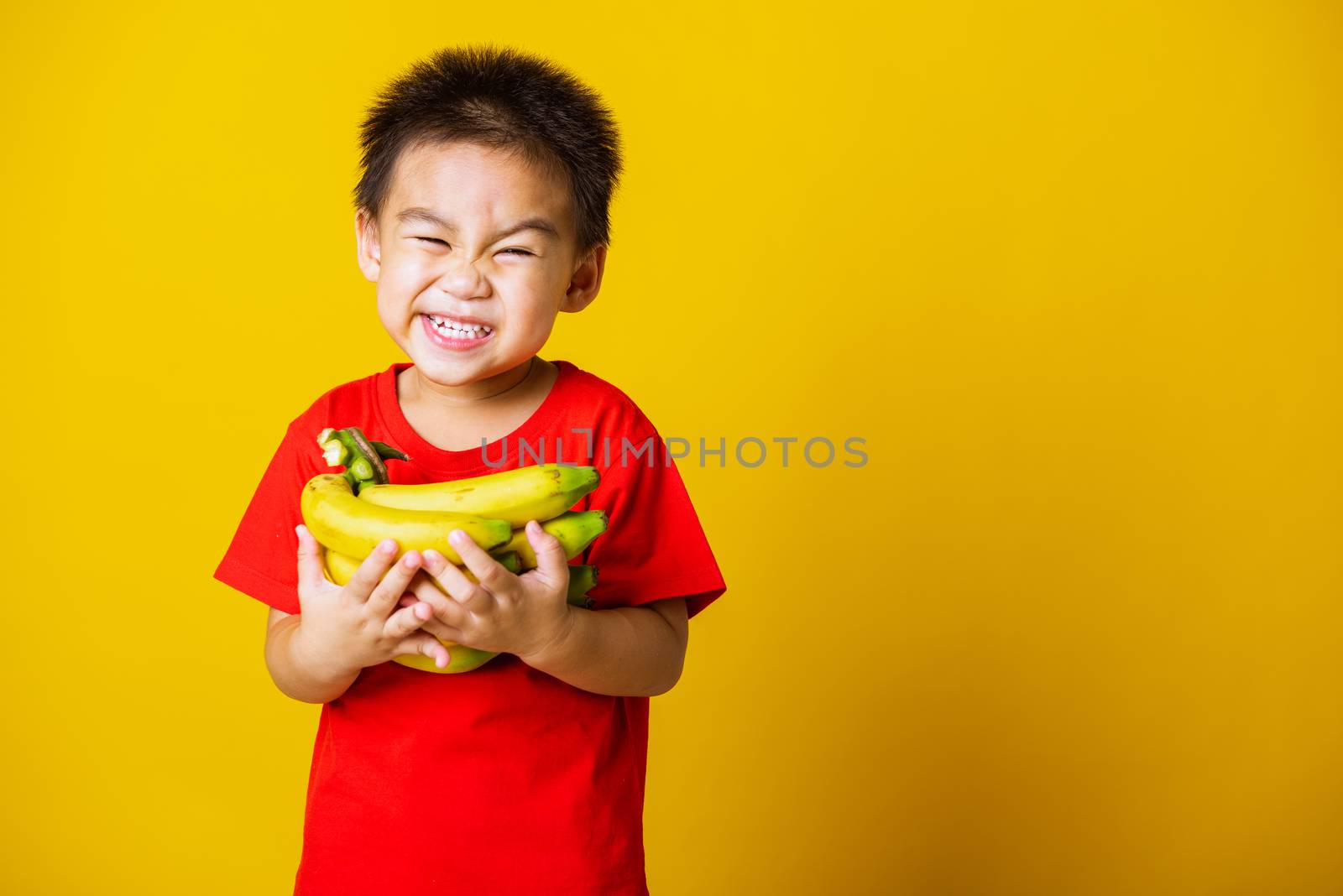 child or kid cute little boy attractive smile playing holds bana by Sorapop