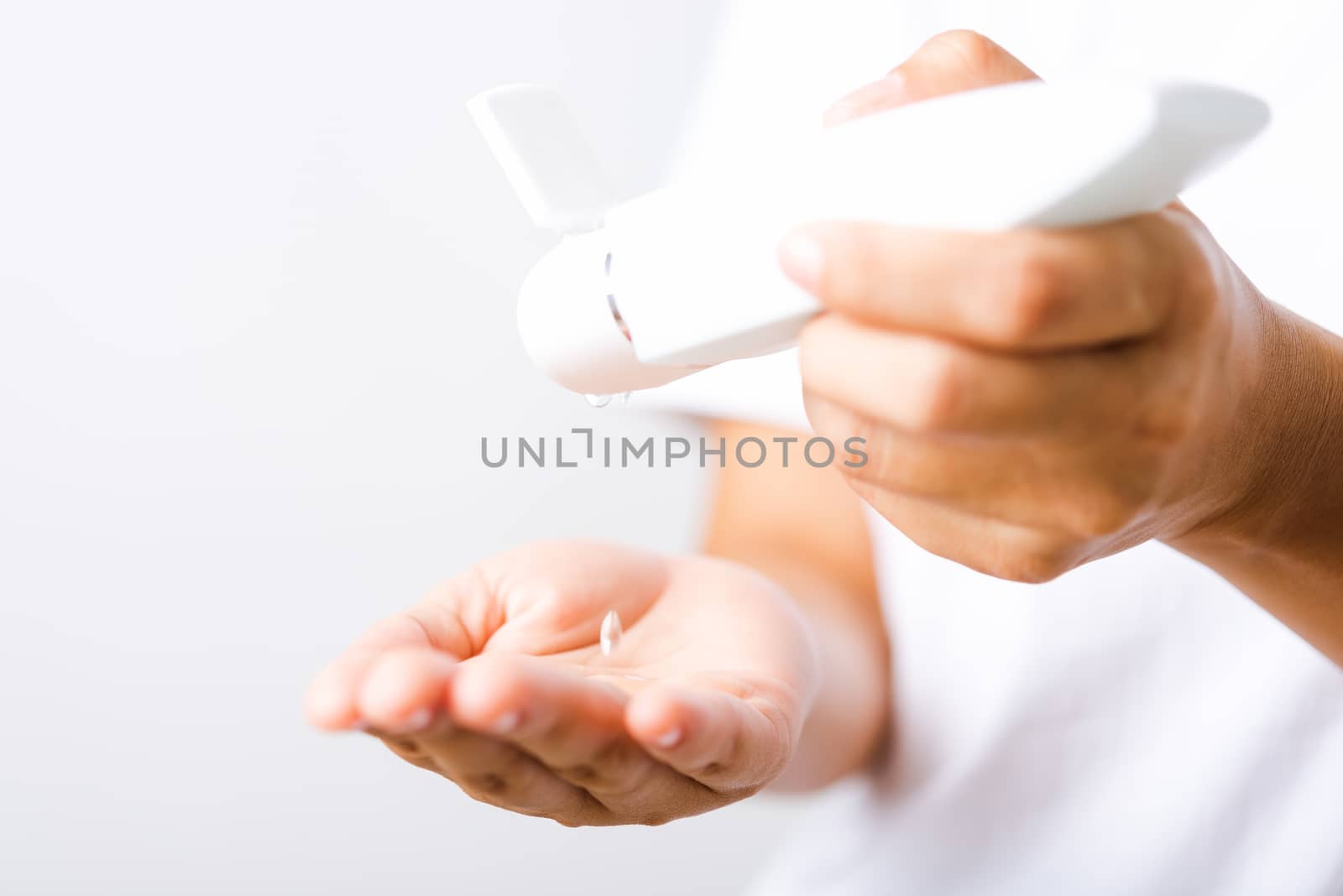 Closeup Hand Asian young woman applying drop dispenser sanitizer alcohol gel on hand wash cleaning, hygiene prevention COVID-19 or coronavirus protection concept, isolated on white background