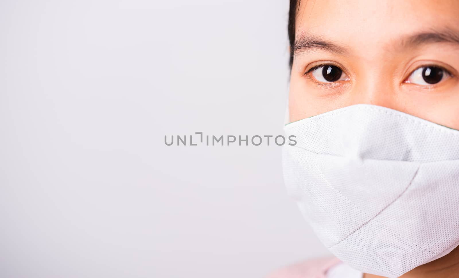 Asian beautiful woman wearing protection face mask against coronavirus her looking to camera, studio shot isolated on white background with copy space, COVID-19 or corona virus concept