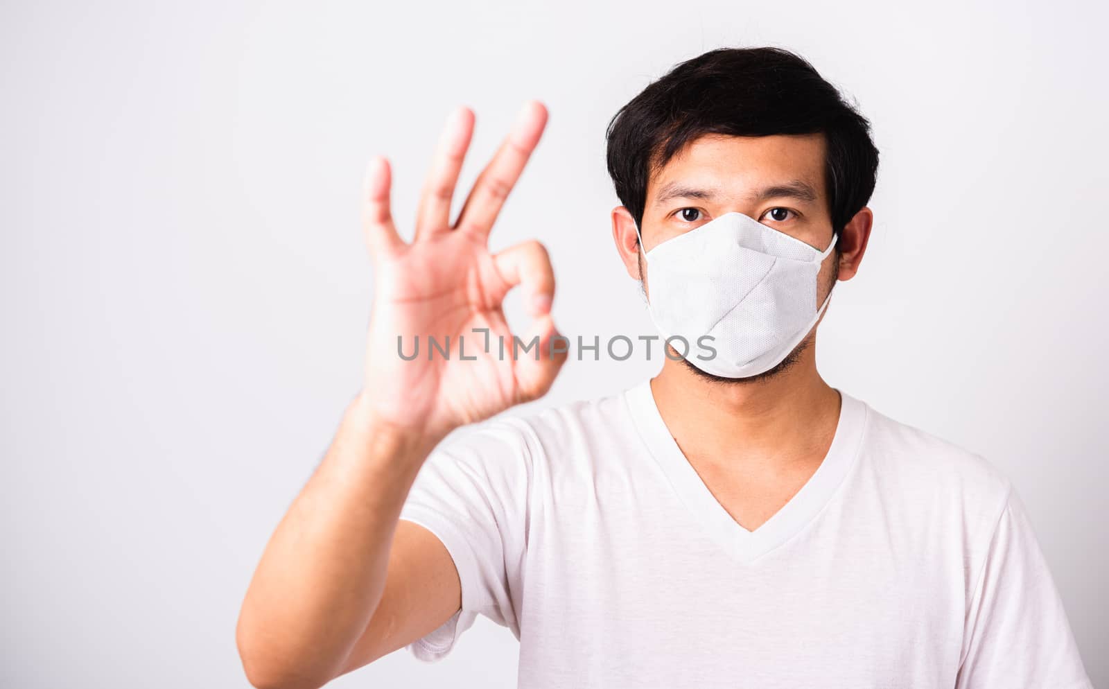 Man wearing surgical hygienic protective cloth face mask against by Sorapop