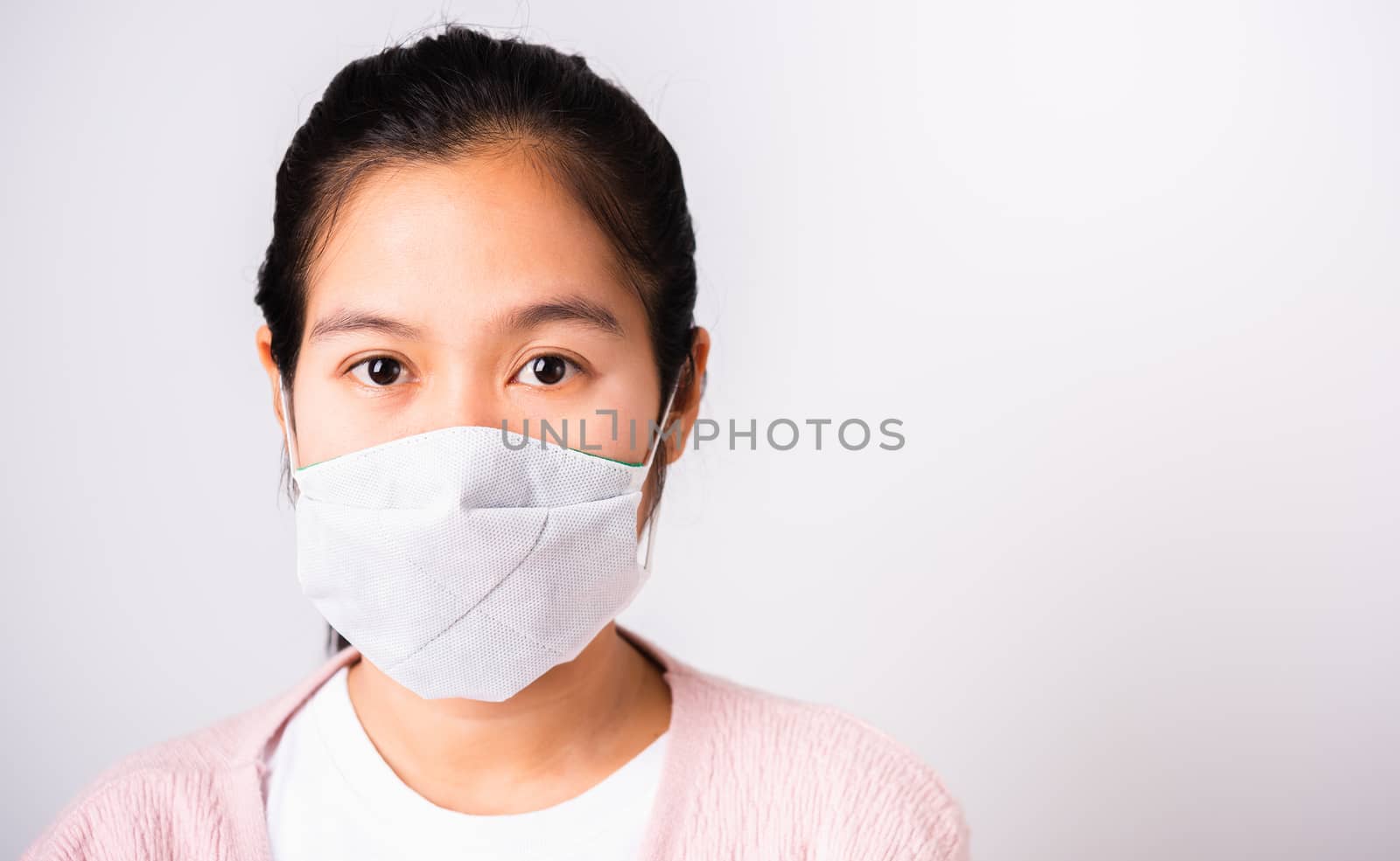 Asian beautiful woman wearing protection face mask against coronavirus her looking to camera, studio shot isolated on white background with copy space, COVID-19 or corona virus concept