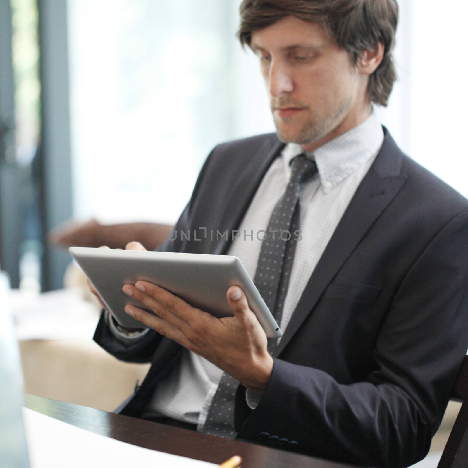 Business man with tablet pc working at office desk