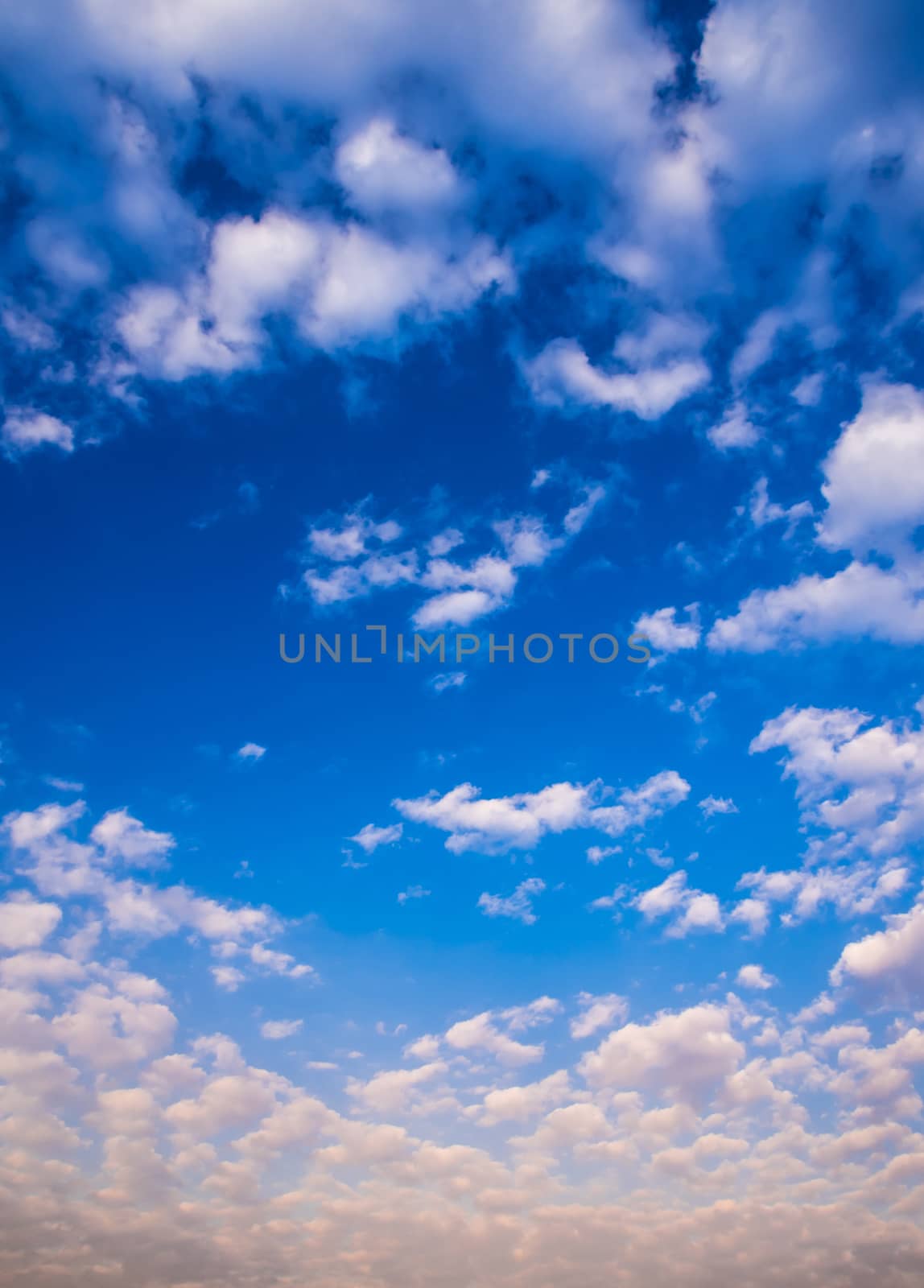 White fluffy clouds in the blue sky with morning light from the sunrise