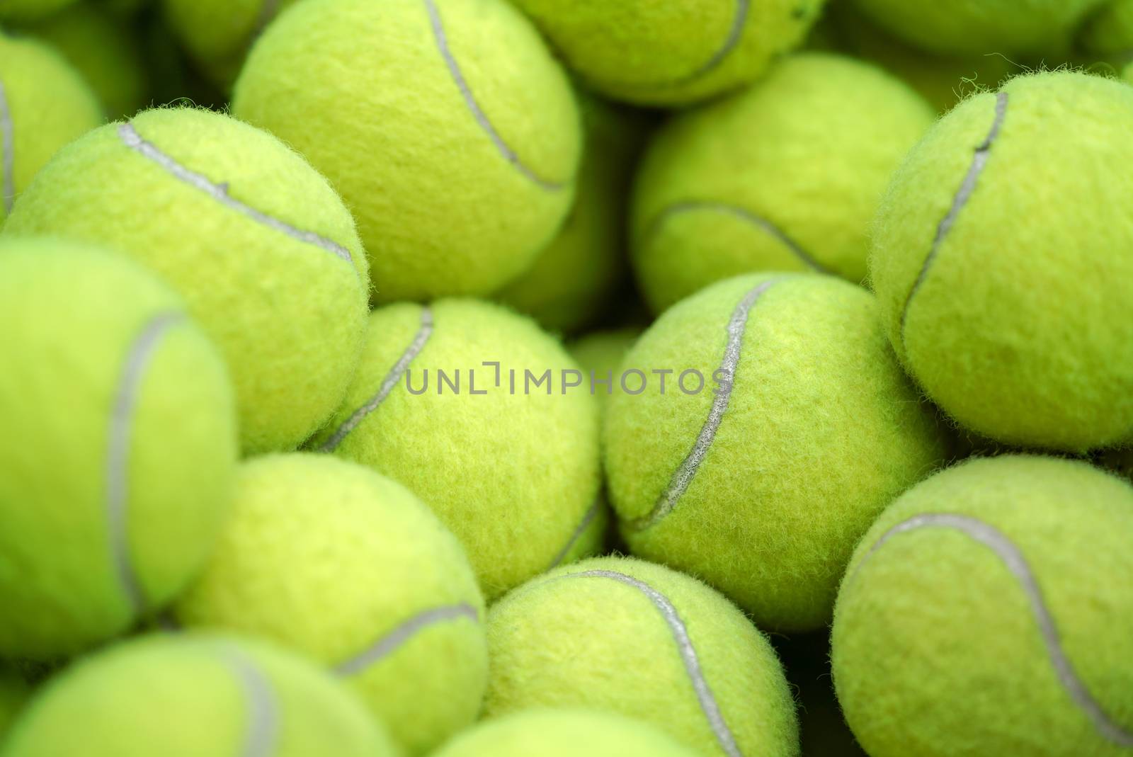 Many green tennis balls are in the basket. (Sport Background)