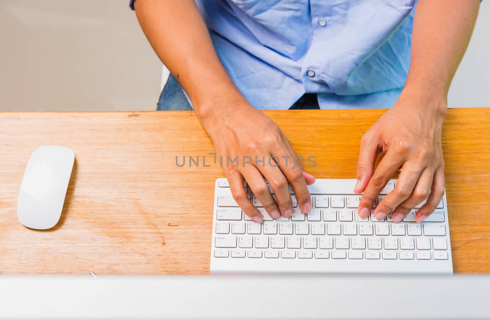 Top view overhead flat lay of Asian businessman working write keyboard computer on desk home office under curfew quarantine pandemic coronavirus COVID-19, work from home concept