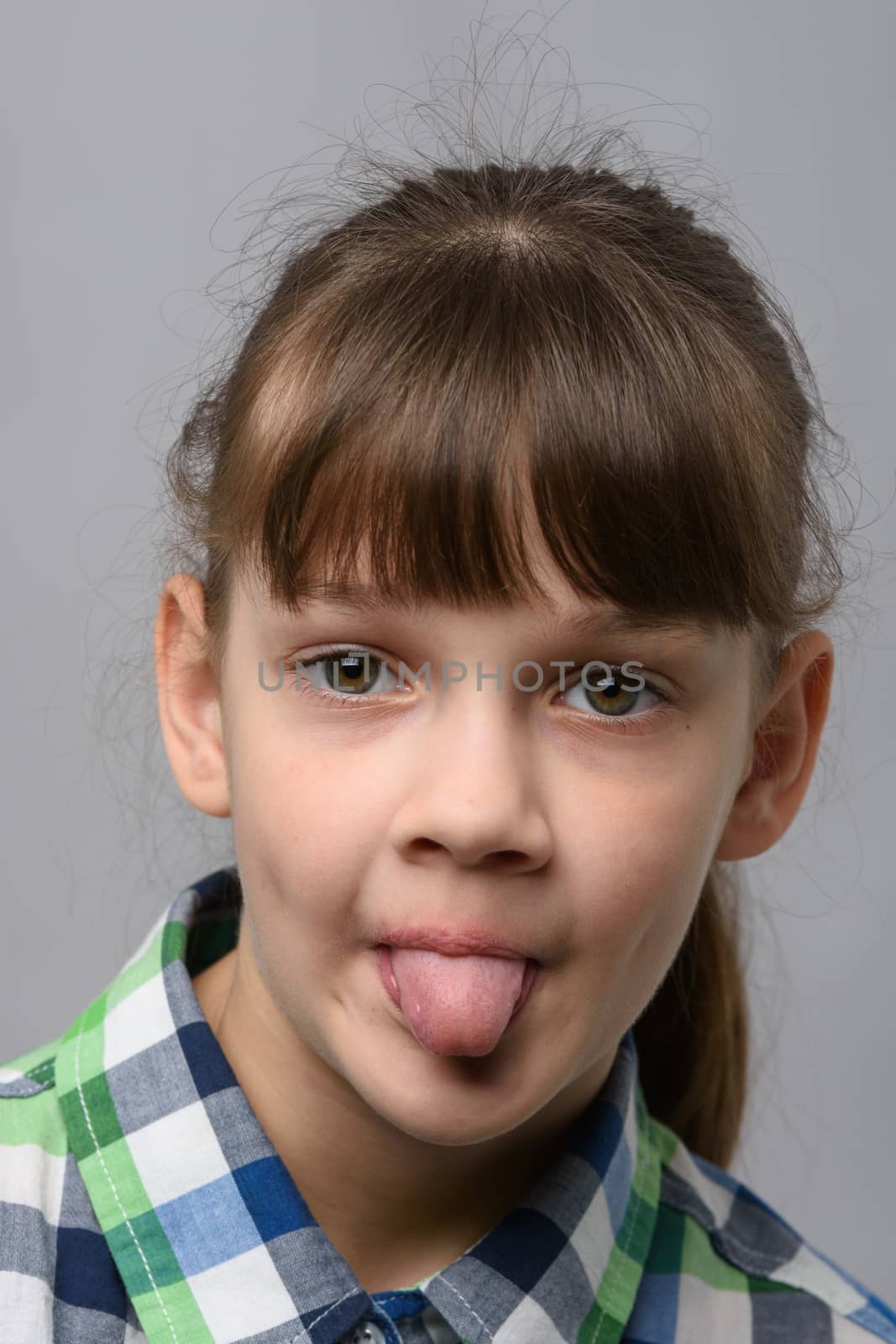 Portrait of a ten-year-old girl showing tongue, European appearance, close-up