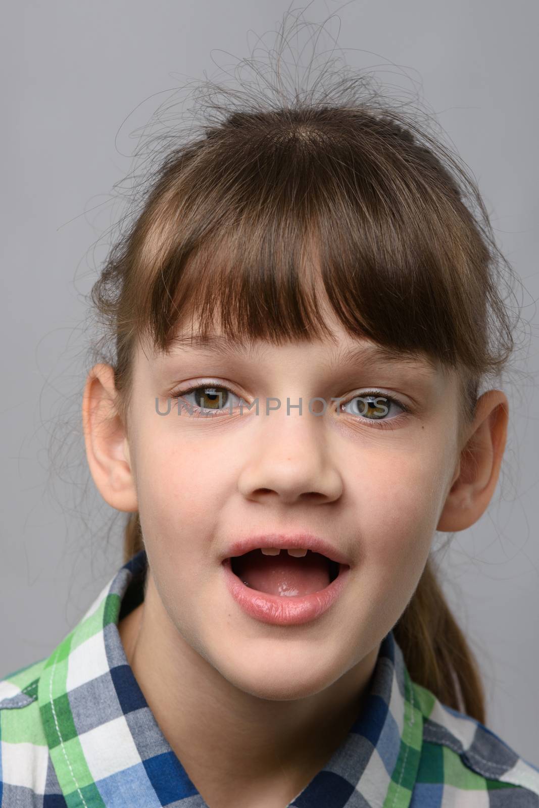 Portrait of a funny ten-year-old girl with wide mouth, European appearance, close-up