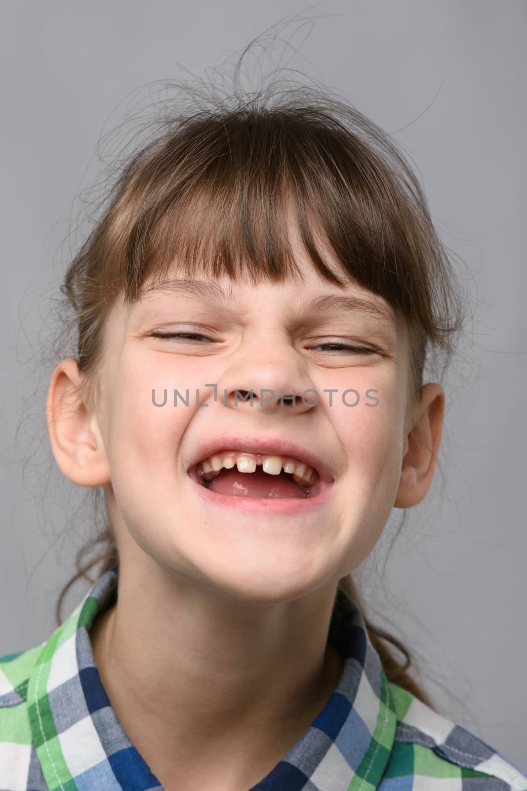 Portrait of a joyfully smiling ten-year-old girl of European appearance, close-up