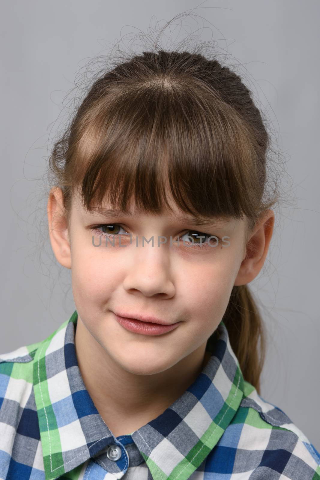 Portrait of embarrassed ten-year-old girl, European appearance, close-up