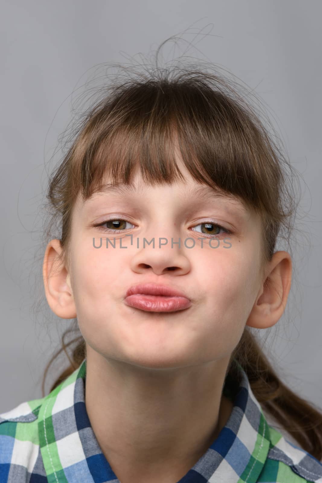 Portrait of a ten-year-old girl showing a kiss, European appearance, close-up