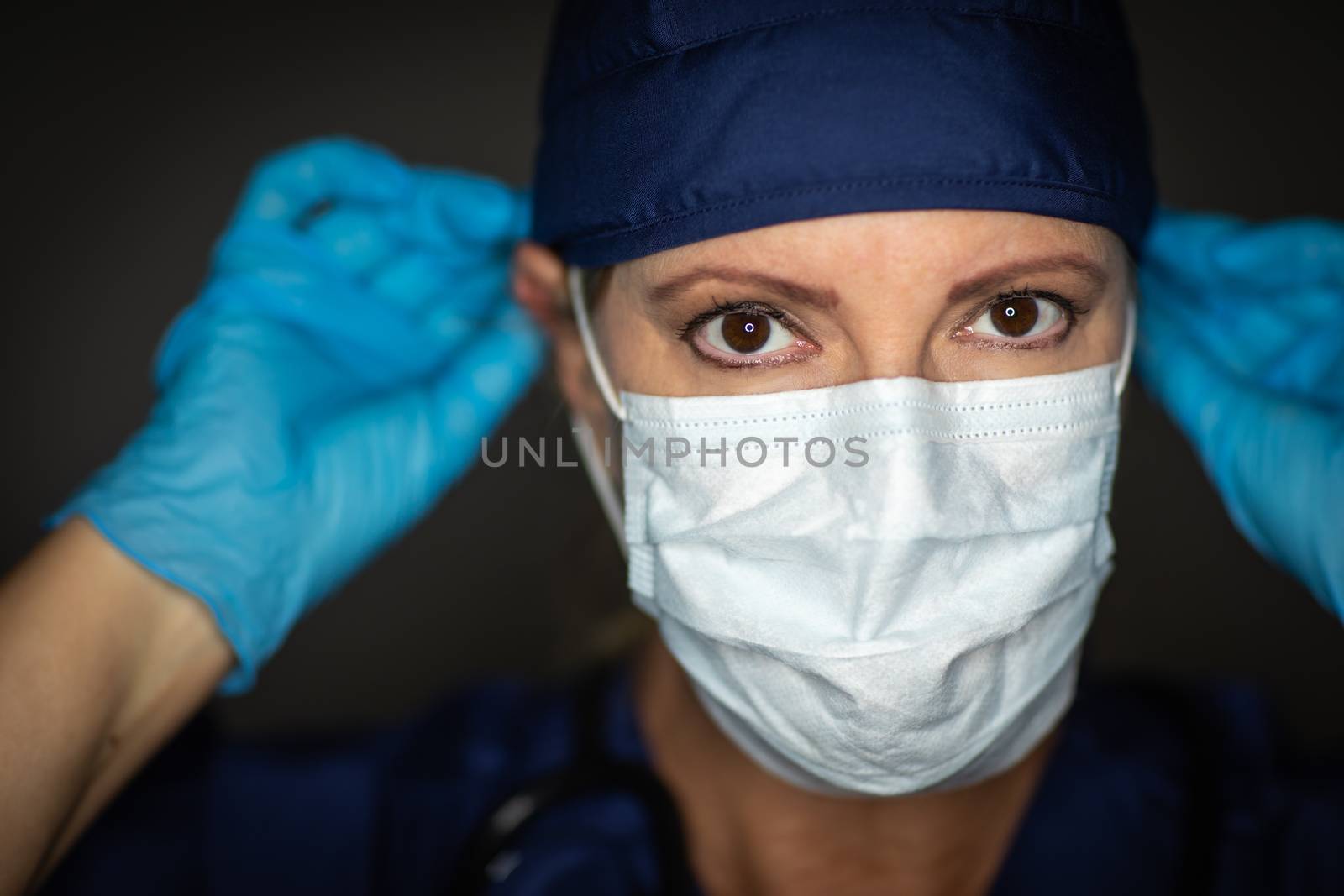 Female Doctor or Nurse Wearing Surgical Gloves Putting On Medical Face Mask. by Feverpitched
