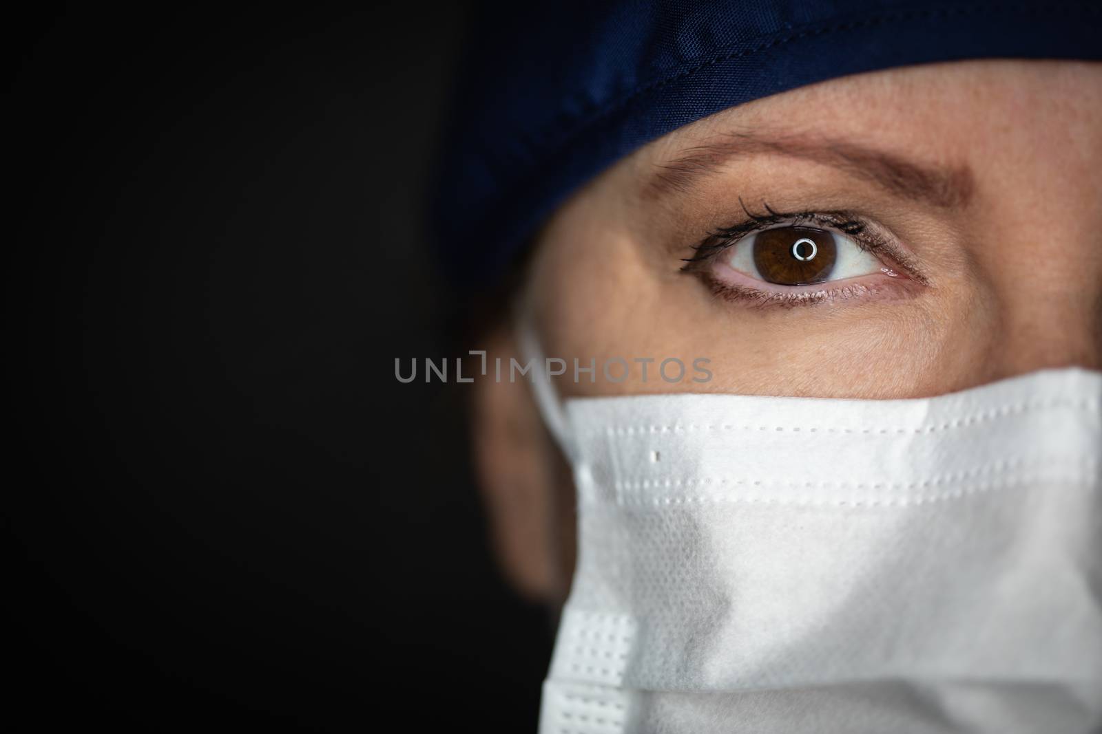 Female Doctor or Nurse Wearing Medical Face Mask on Dark Background.