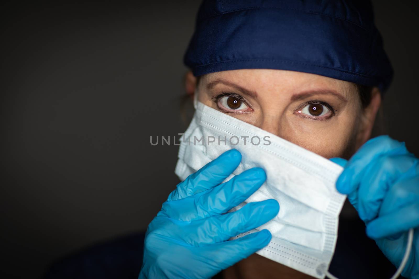 Female Doctor or Nurse Wearing Surgical Gloves Putting On Medical Face Mask.