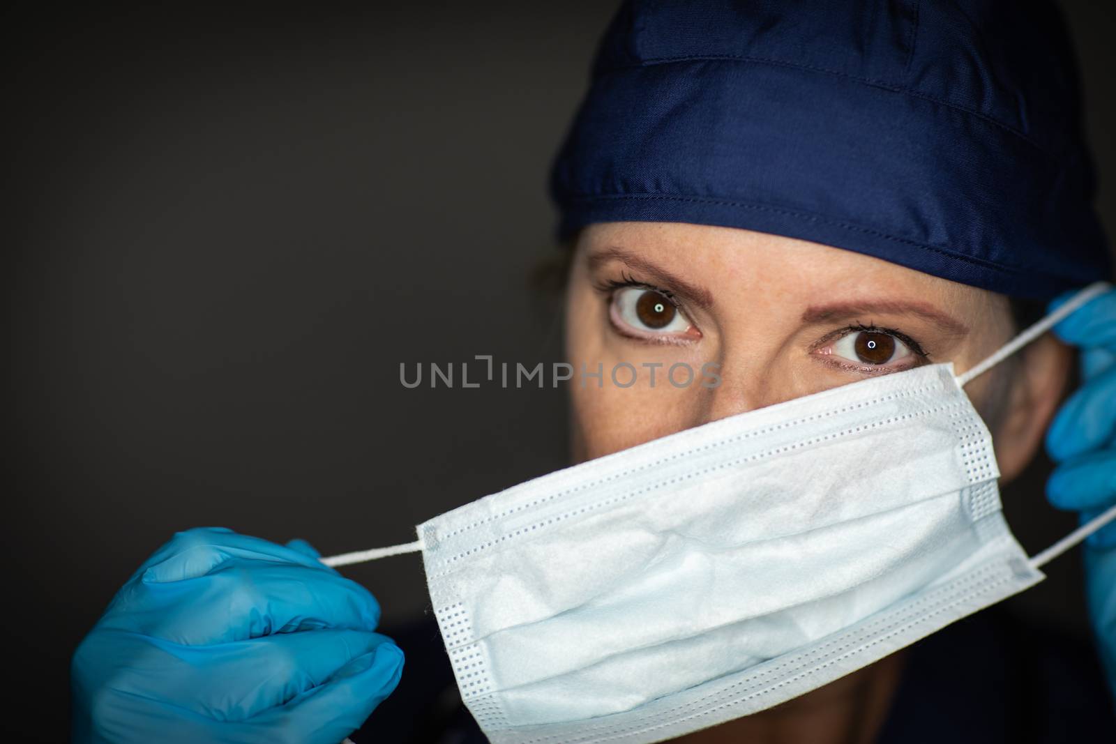 Female Doctor or Nurse Wearing Surgical Gloves Putting On Medical Face Mask.