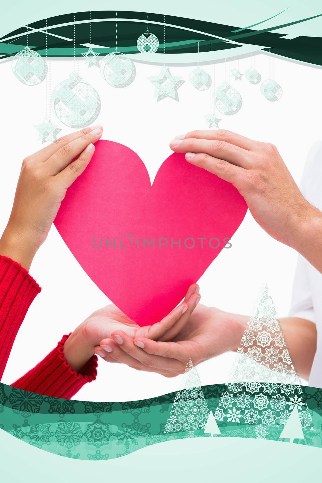 Couples hands holding pink heart against christmas frame