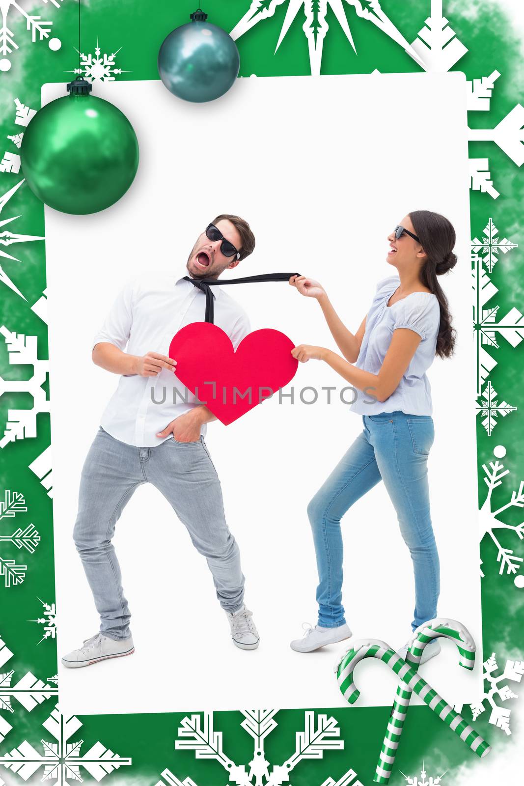 Brunette pulling her boyfriend by the tie against christmas frame