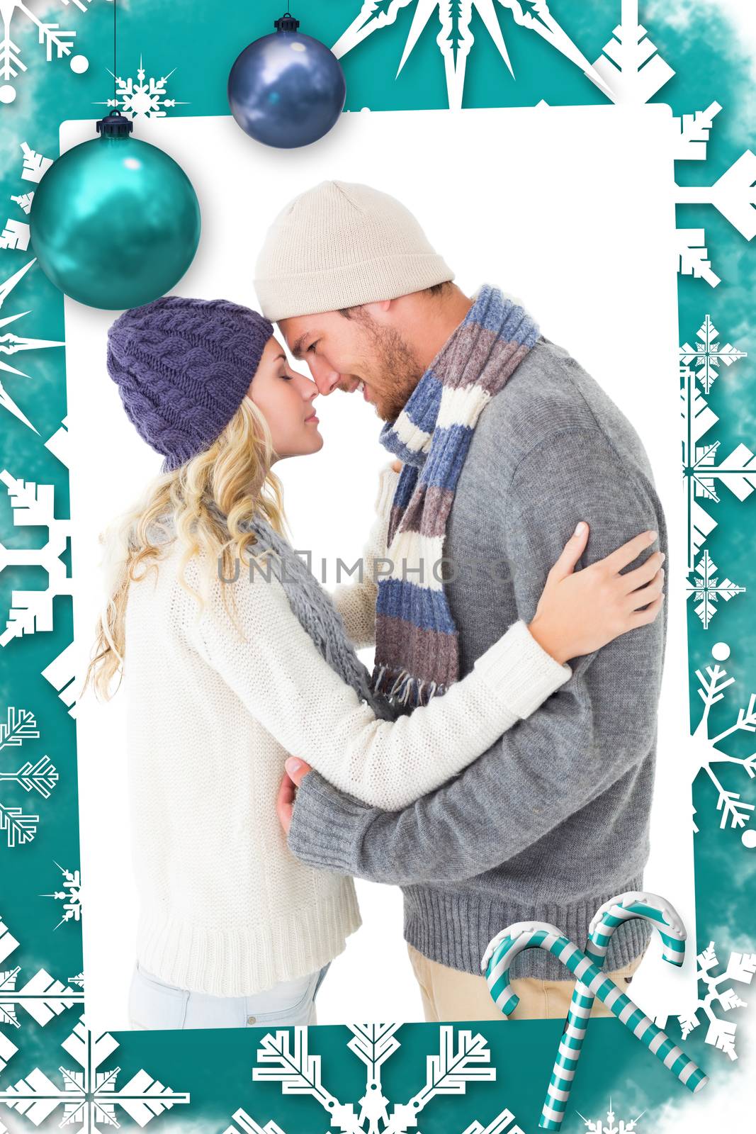 Attractive couple in winter fashion hugging against christmas frame