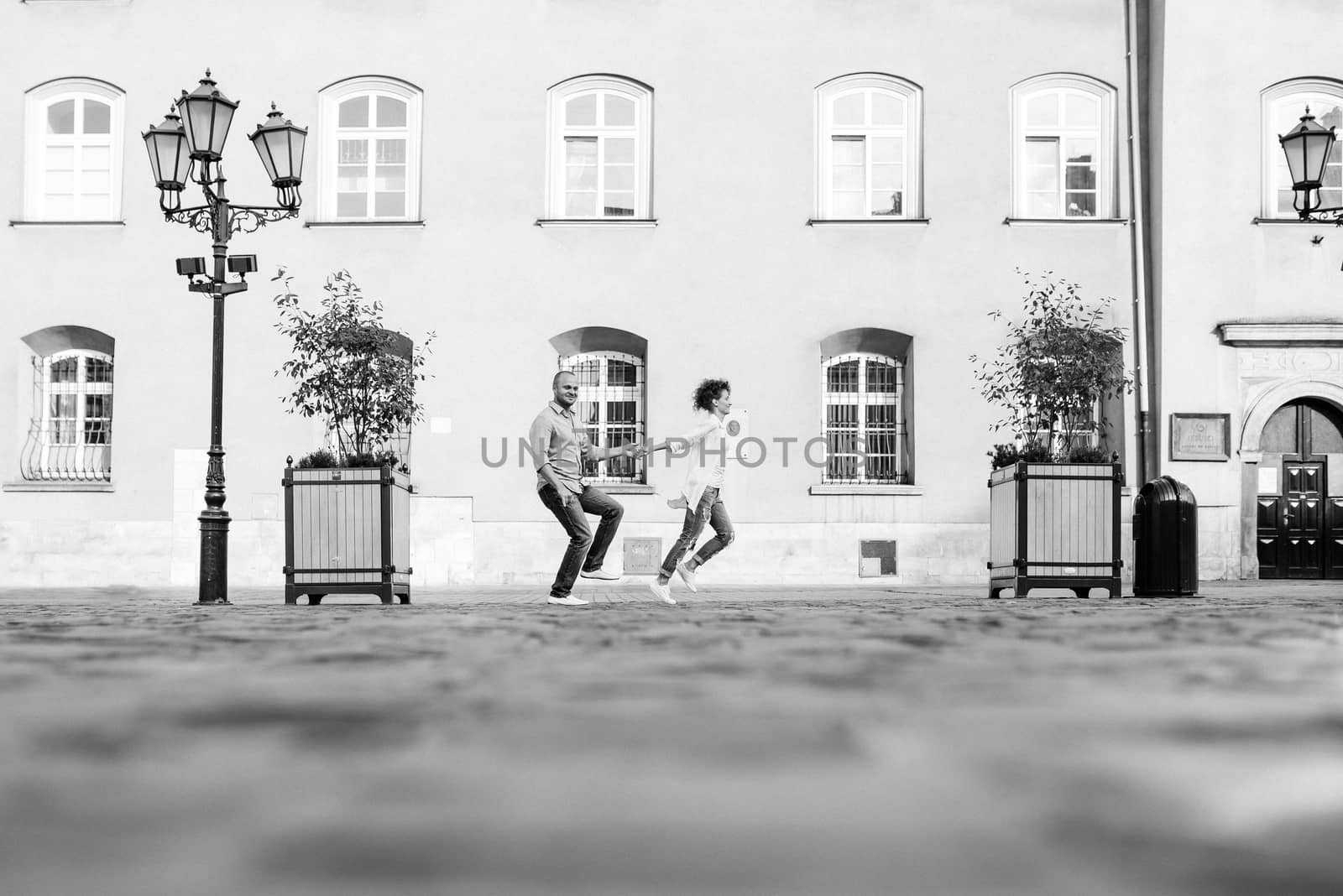 guy and a girl happily walk in the morning on the empty streets by Andreua