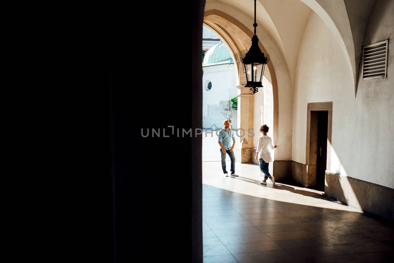 guy and a girl happily walk in the morning on the empty streets of old Europe