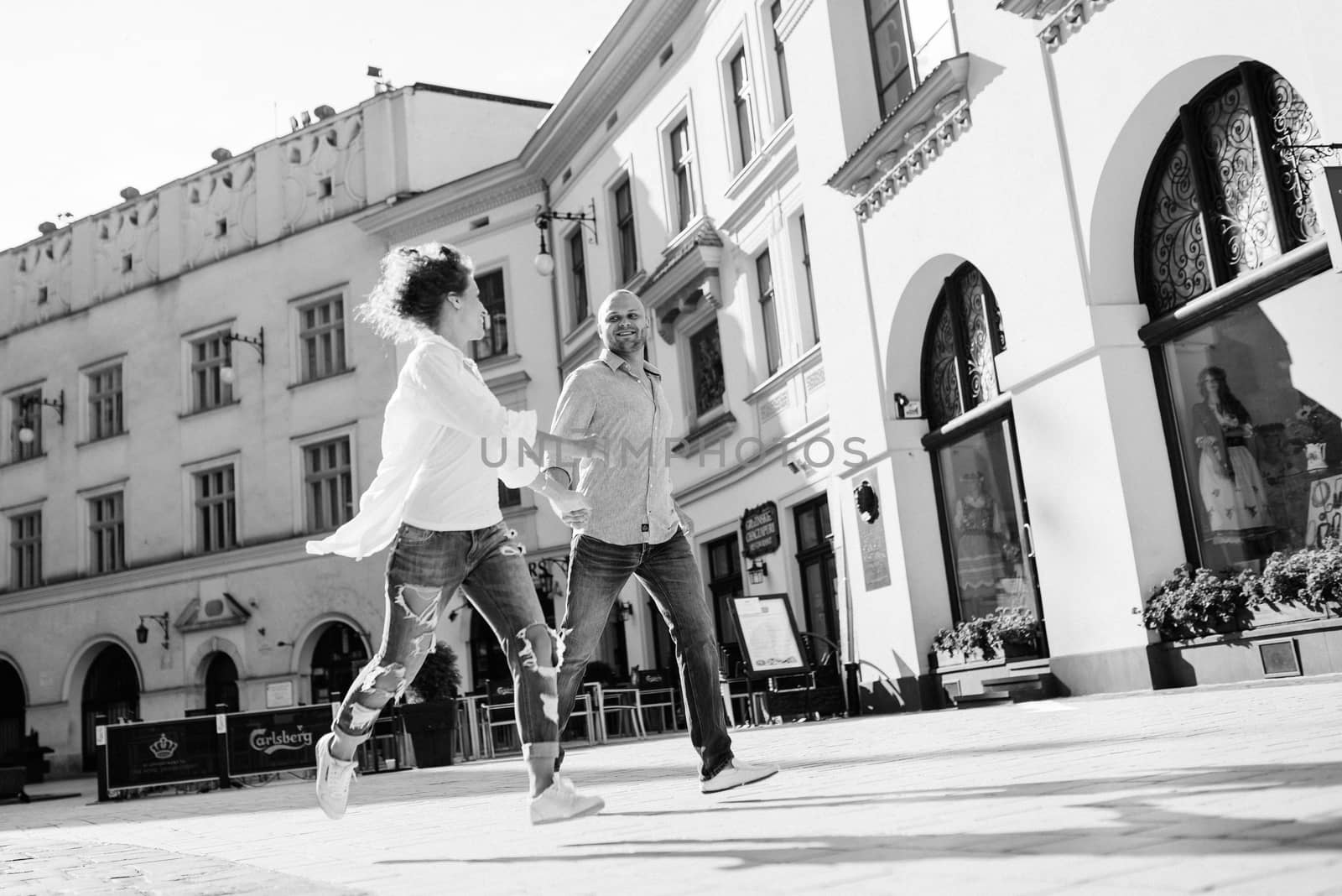 guy and a girl happily walk in the morning on the empty streets of old Europe