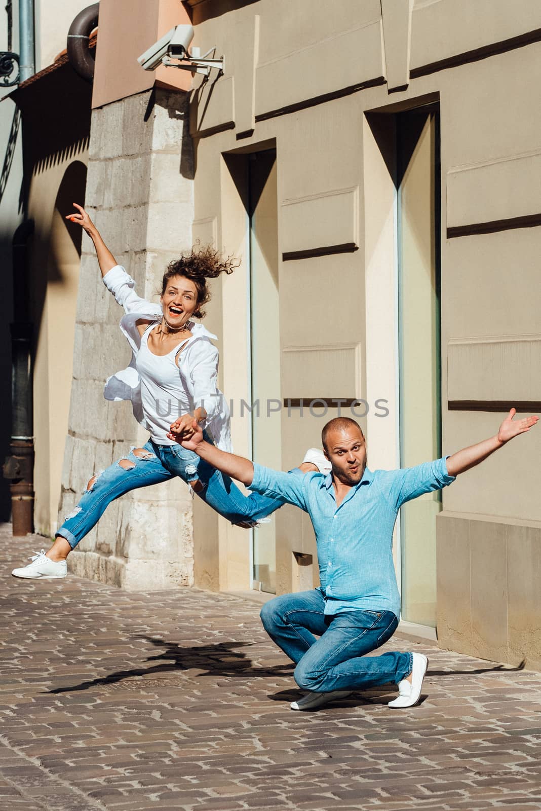 guy and a girl happily walk in the morning on the empty streets of old Europe