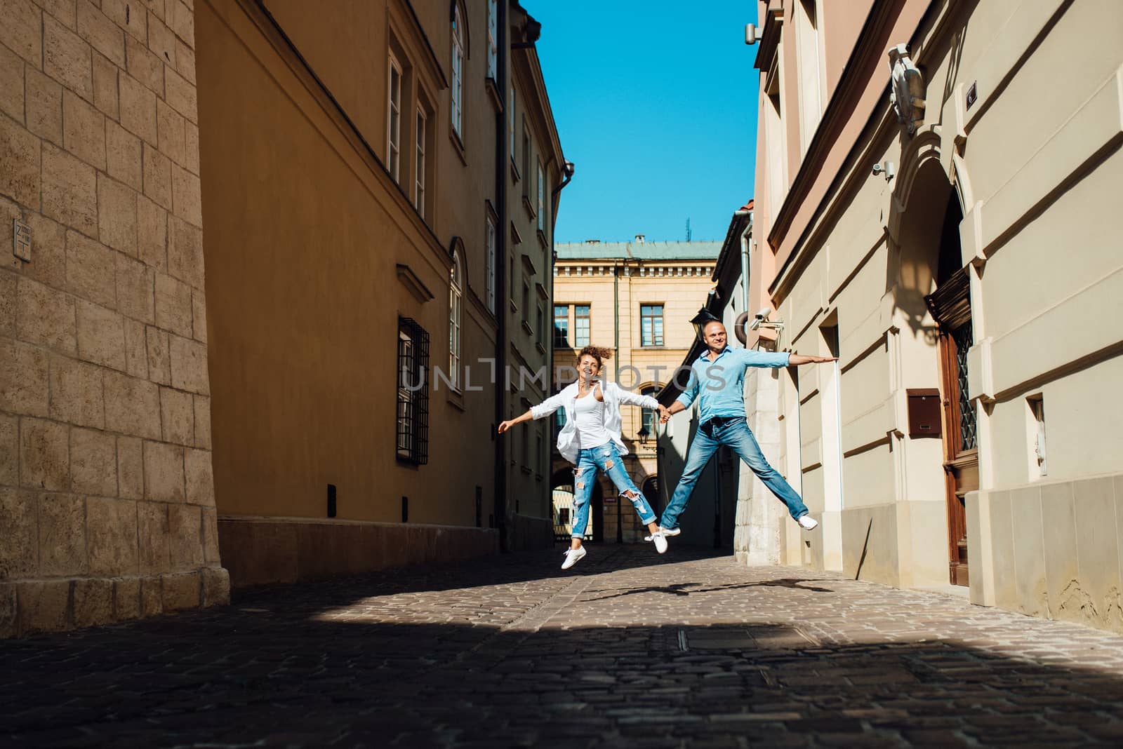 guy and a girl happily walk in the morning on the empty streets of old Europe