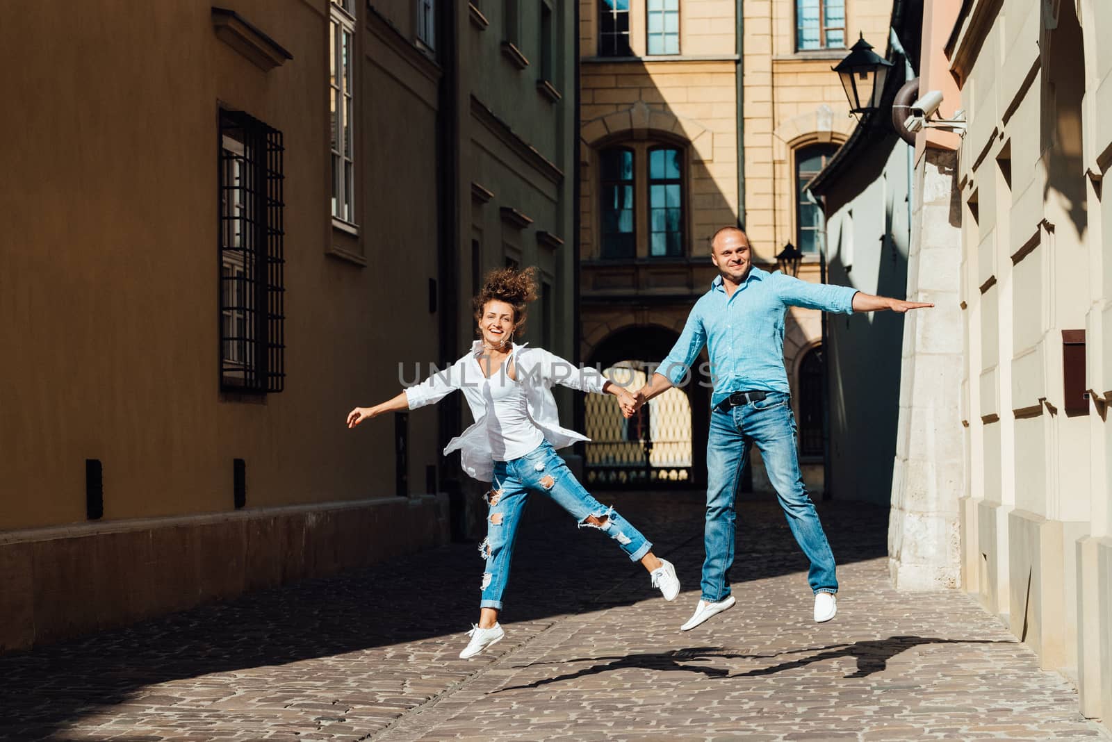 guy and a girl happily walk in the morning on the empty streets of old Europe