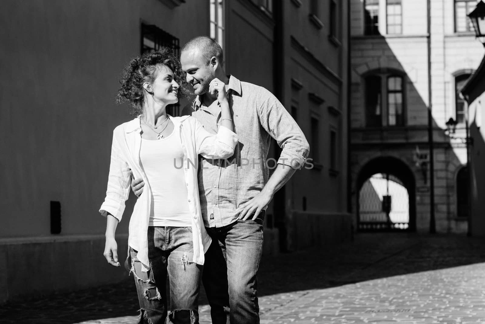 guy and a girl happily walk in the morning on the empty streets of old Europe