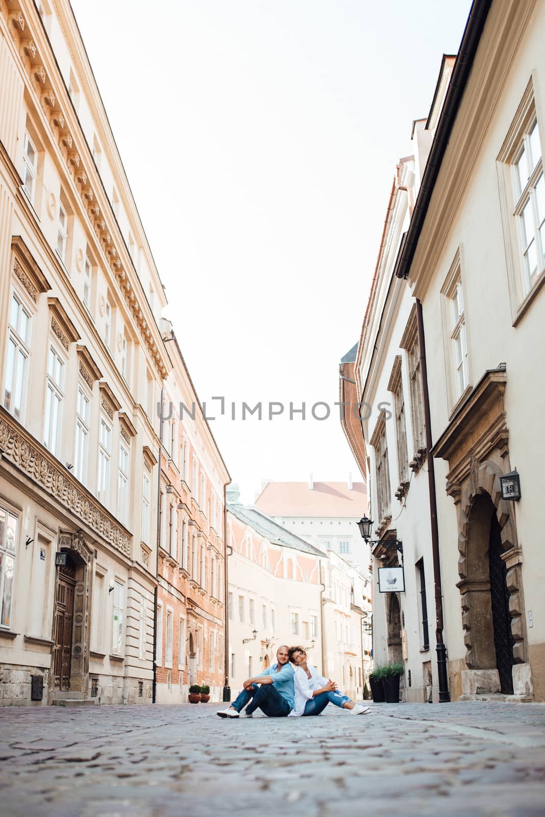 guy and a girl happily walk in the morning on the empty streets of old Europe