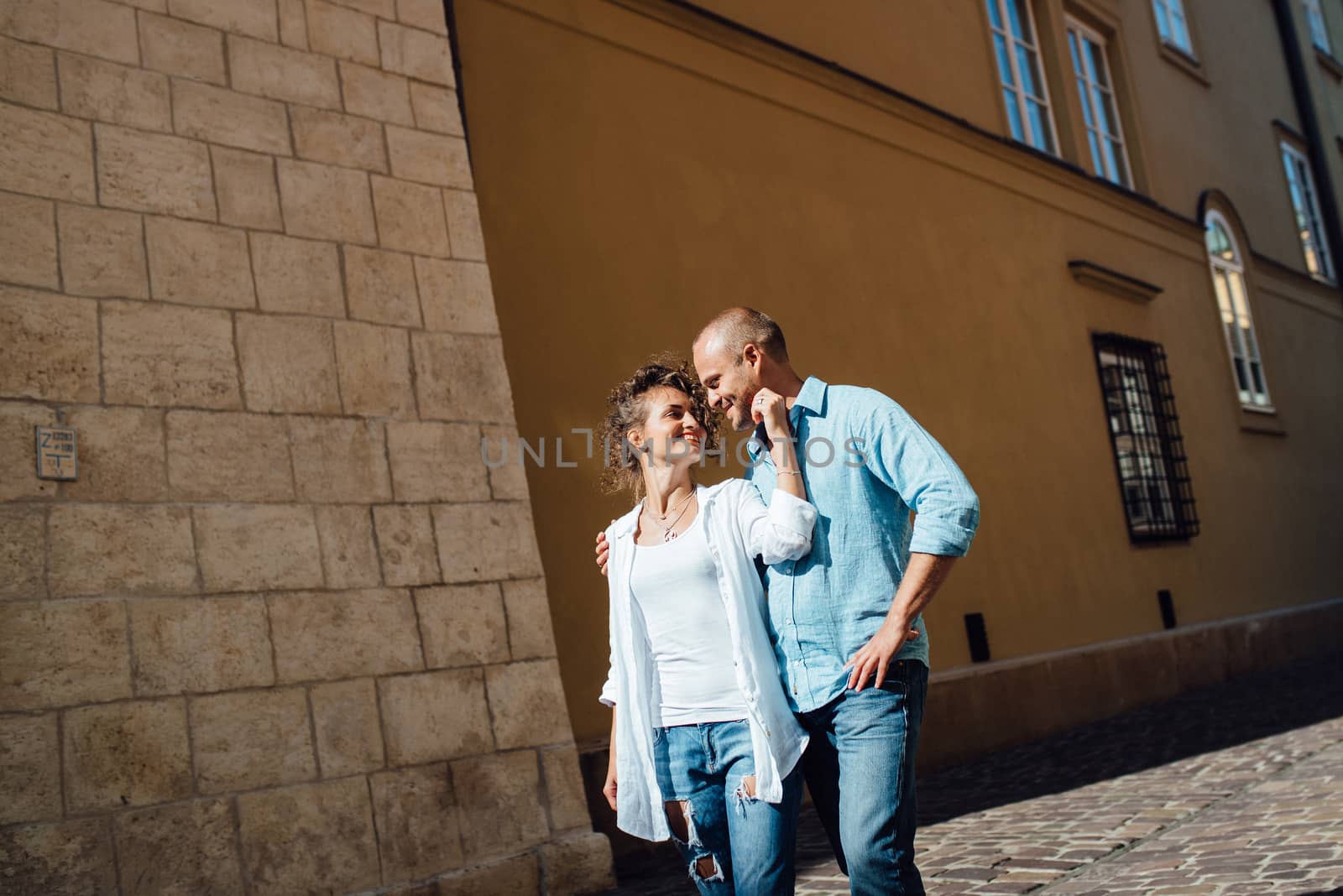 guy and a girl happily walk in the morning on the empty streets of old Europe