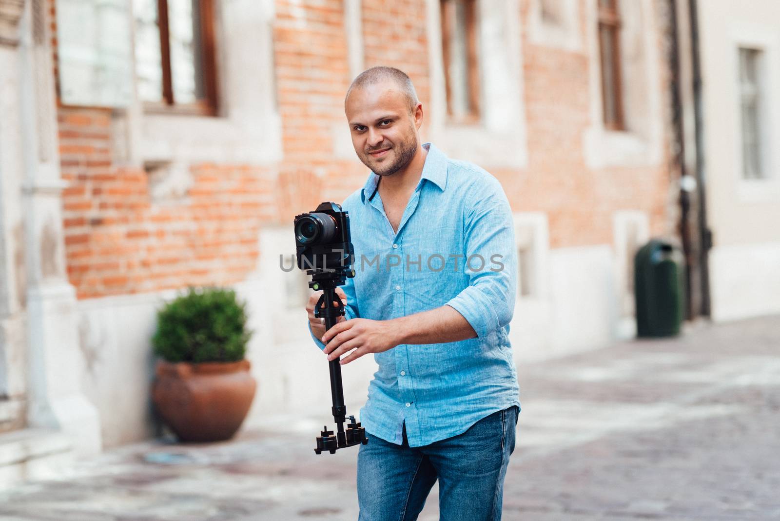 young guy, photographer walking in the old streets poland of europe