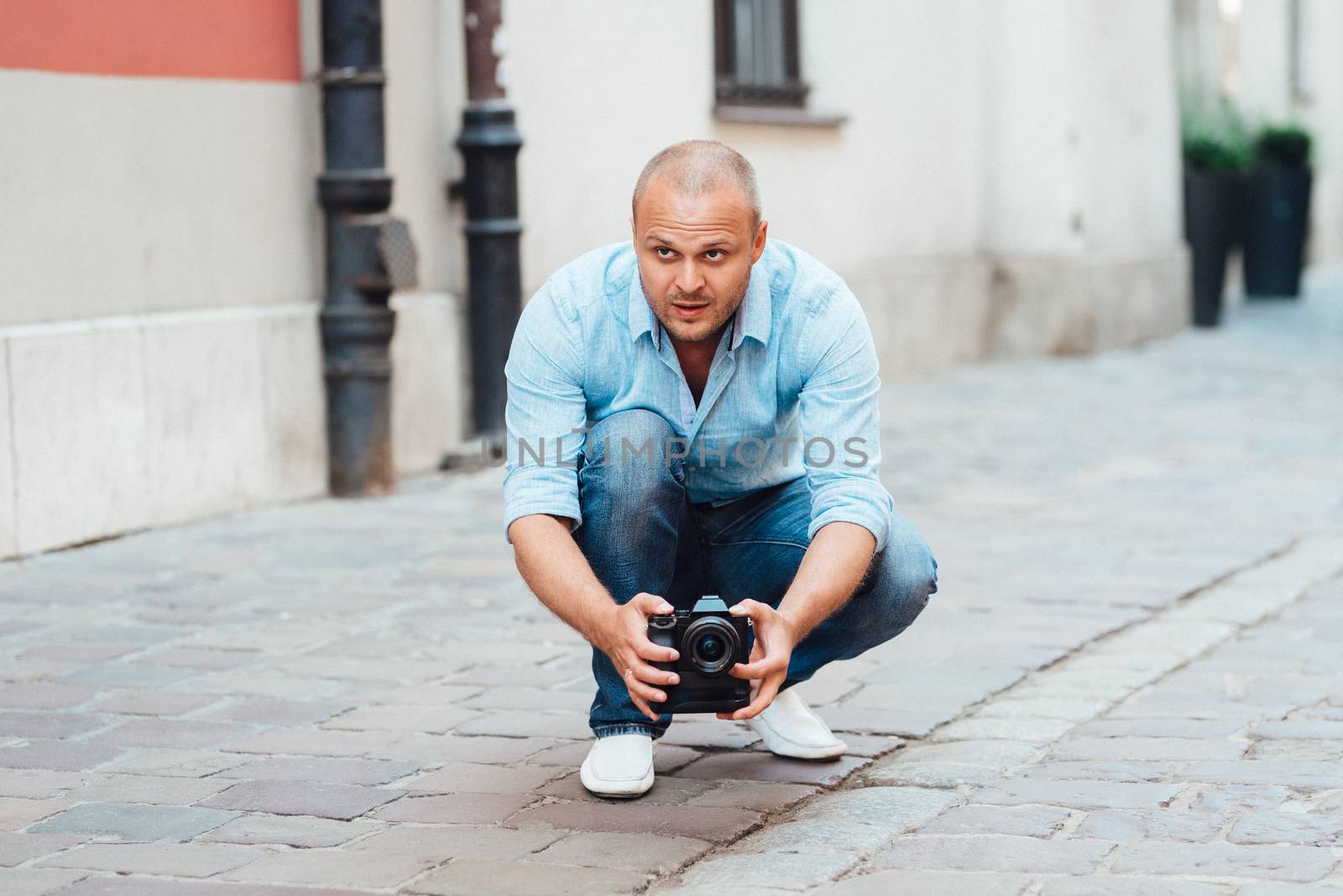 young guy, photographer walking in the old streets poland of europe