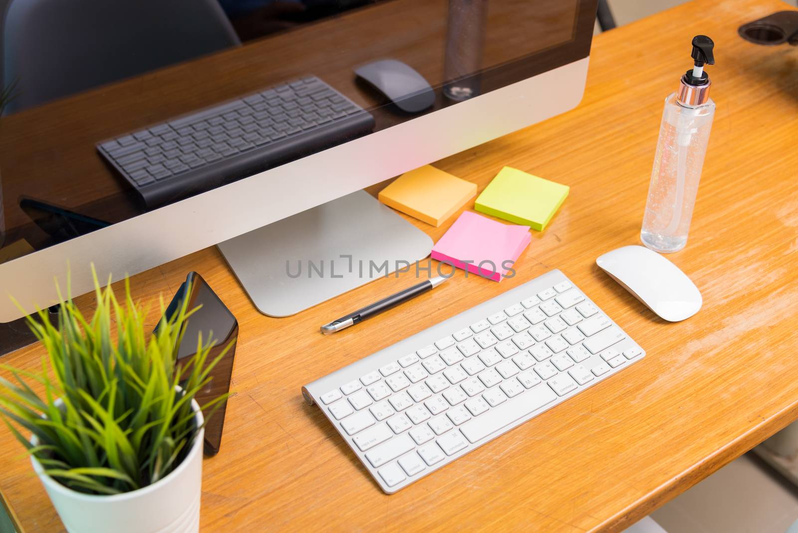 Home office interior blank screen desktop PC computer and smart phone decorations and sanitizing gel on desk under curfew quarantine pandemic coronavirus COVID-19, work from home concept