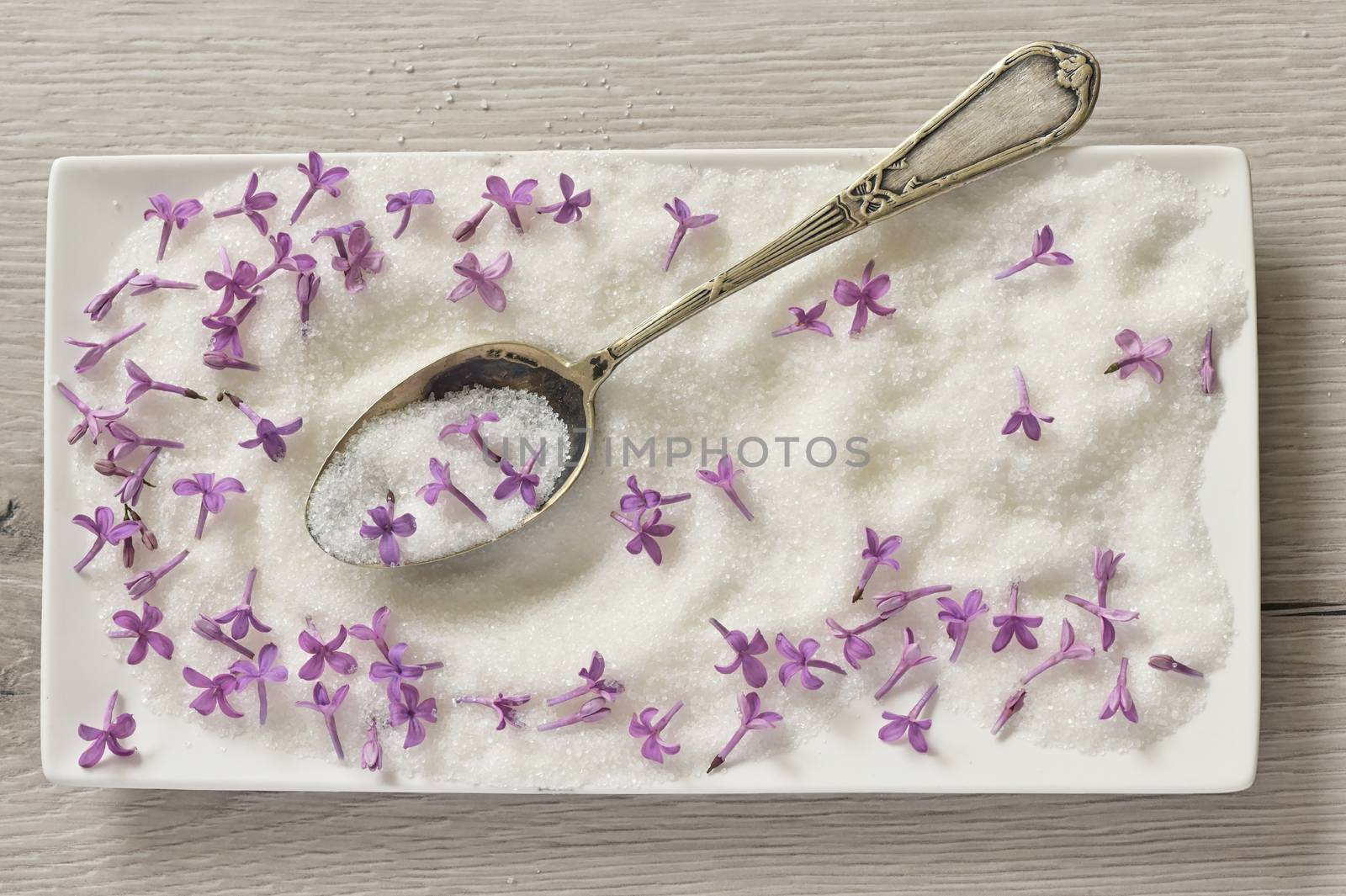 Lilac Sugar In Spoon And Plate On WoodenTable