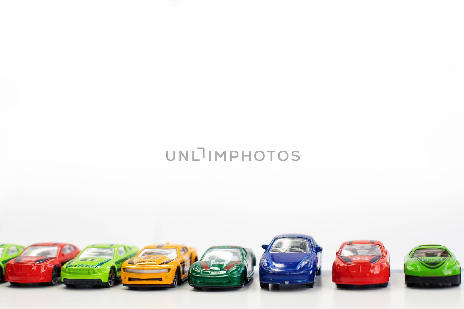 Toy cars of different colors arranged on a white background.