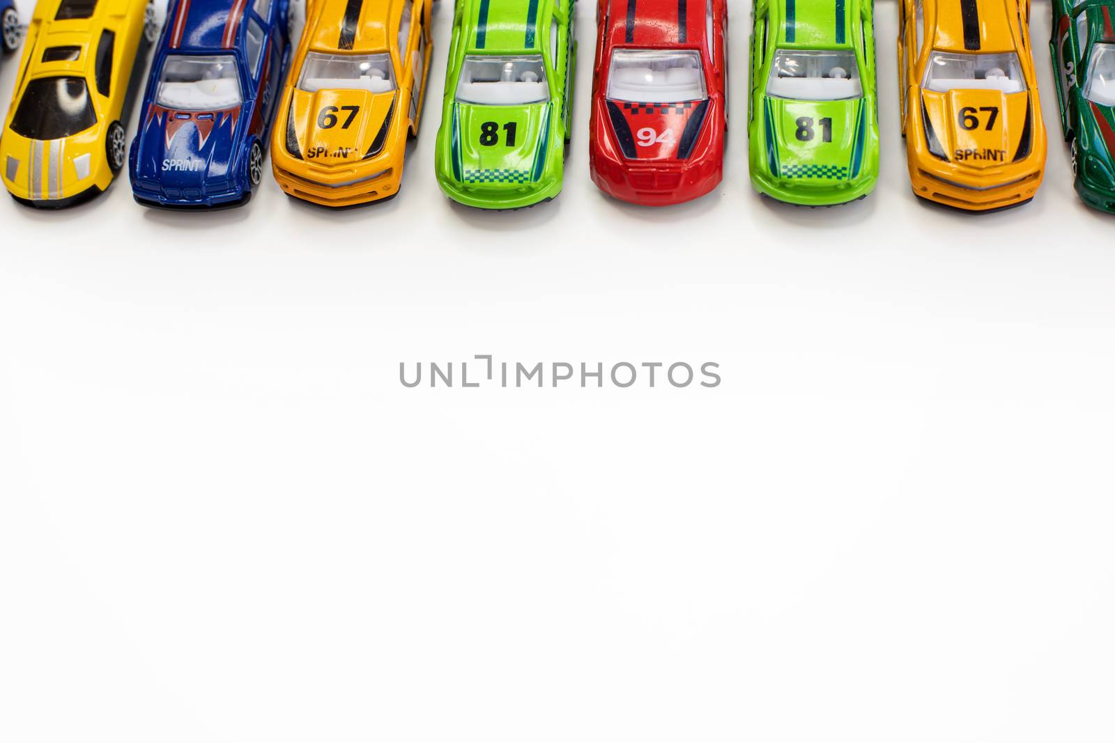 Toy cars of different colors arranged on a white background. by tadeush89