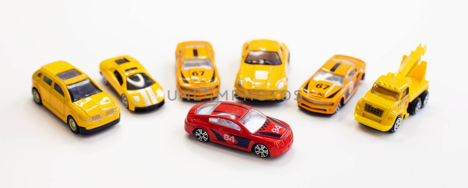 A red car toy surrounded by orange cars by tadeush89