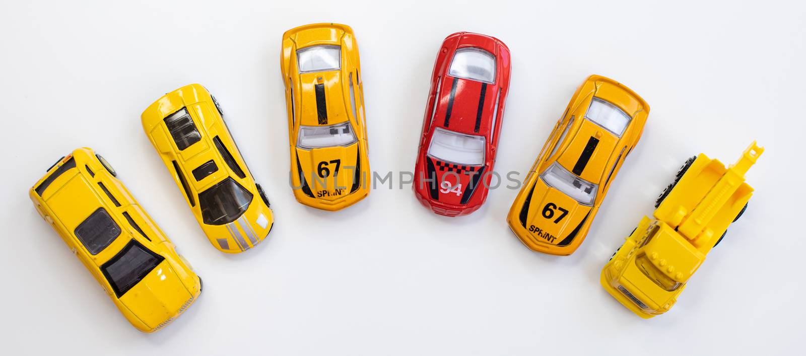 A red car toy surrounded by orange cars by tadeush89