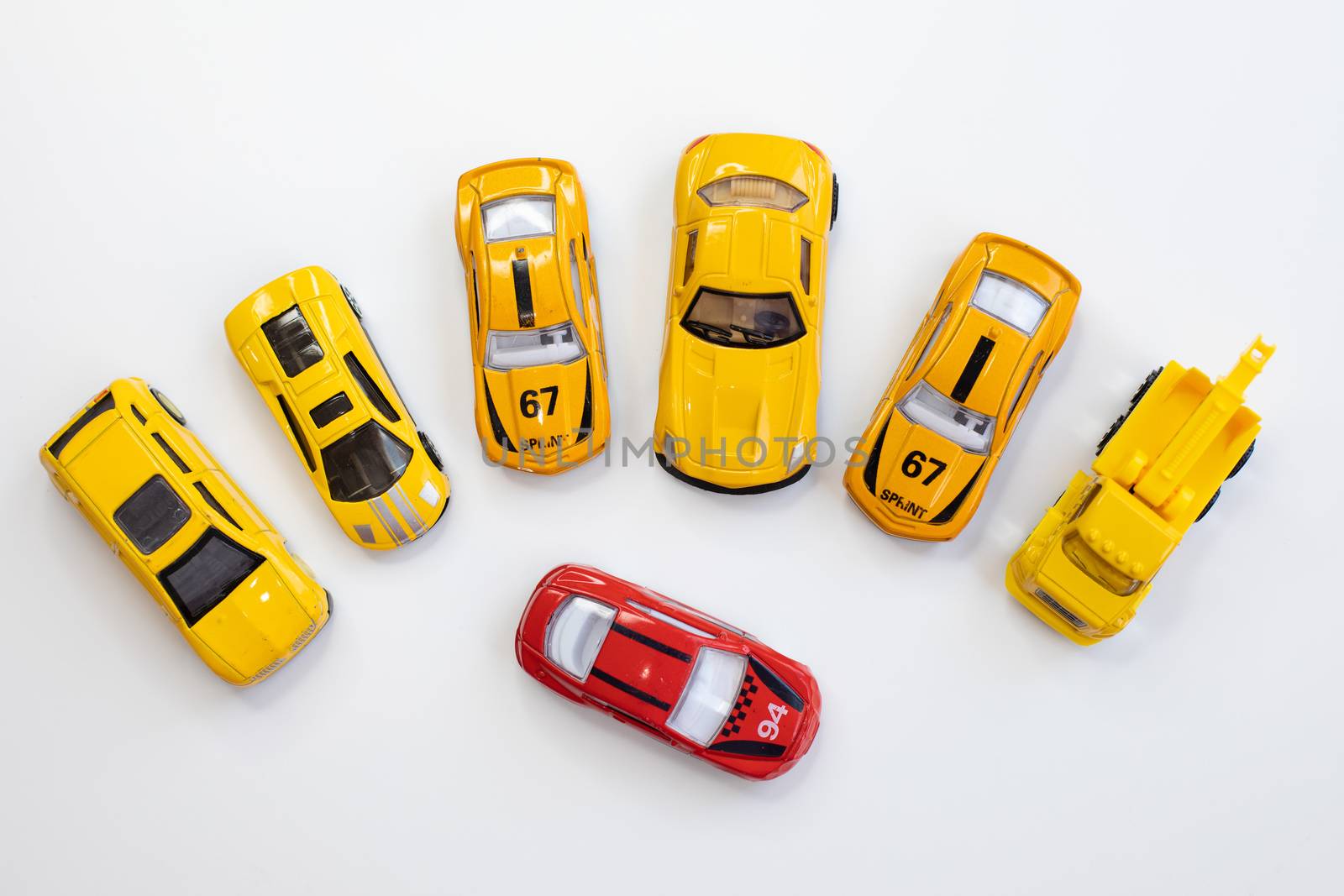 A red car toy surrounded by orange cars by tadeush89