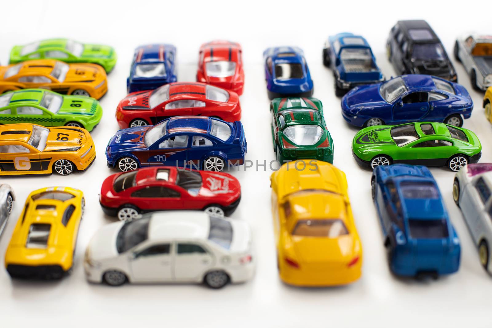 Toy cars of different colors arranged on a white background.