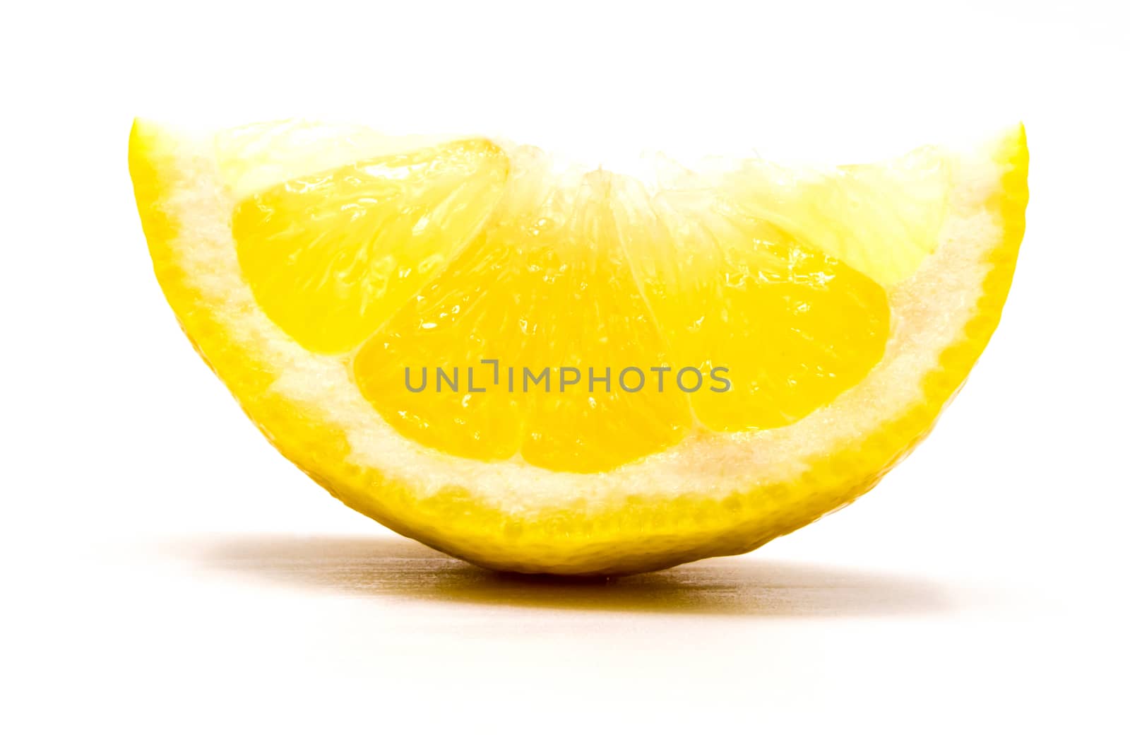 Close up on a slice of fresh lemon wedge isolated on white background as a packaging design element