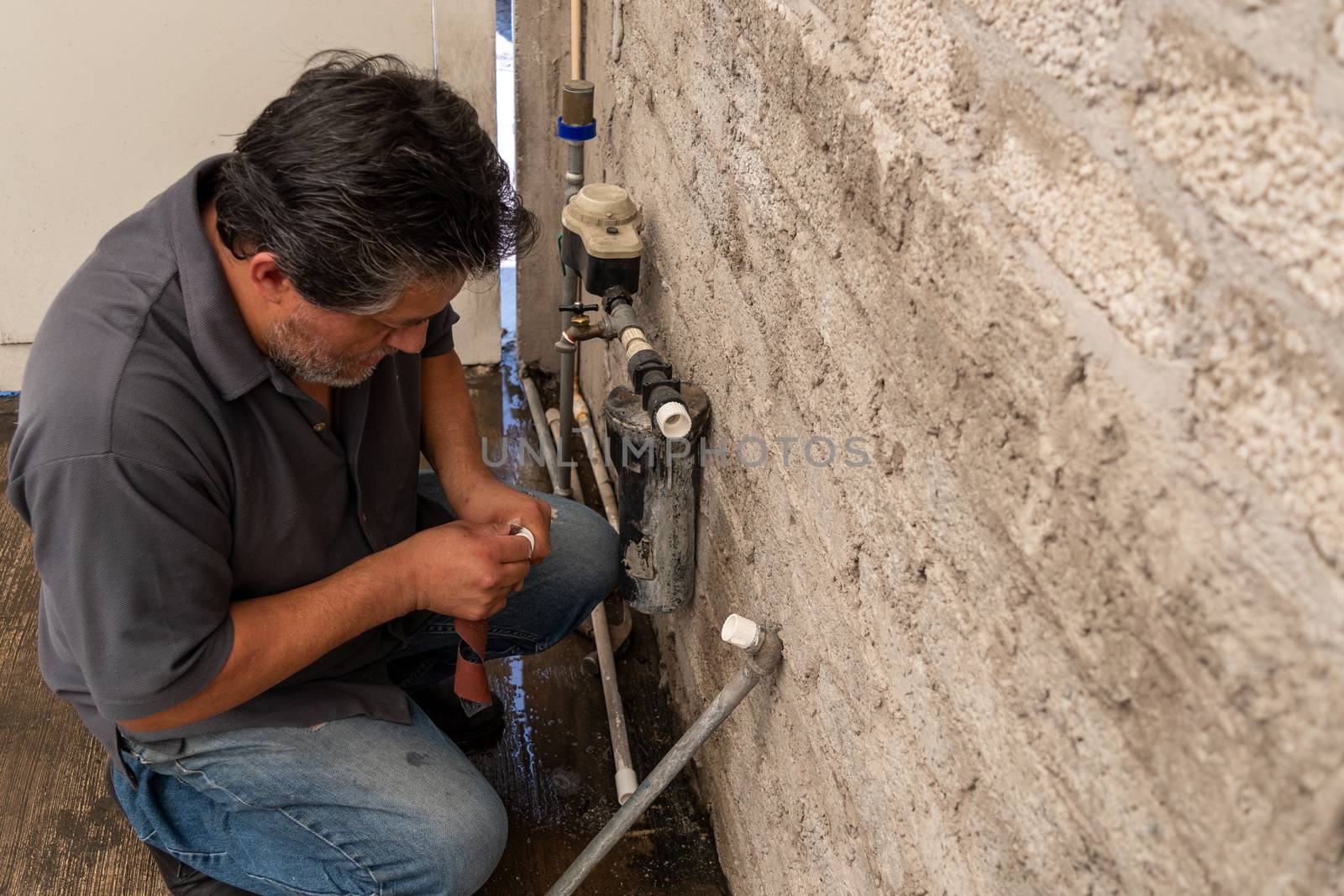 an old man fixing a broken tube of his own house