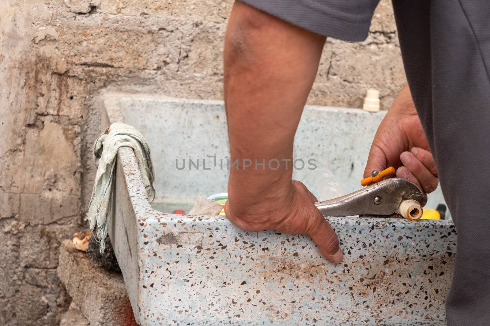 hands of a man fixing a tube of his own house