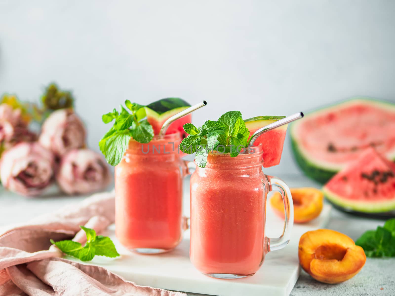 Freshly Blended Watermelon and Peach Smoothies in mason jar and metal straw. Copy space for text or design.