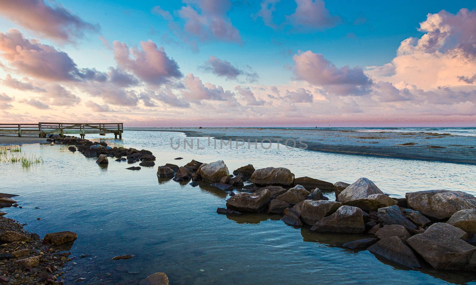 Rock Seawall in Calm Bay at Dusk by dbvirago