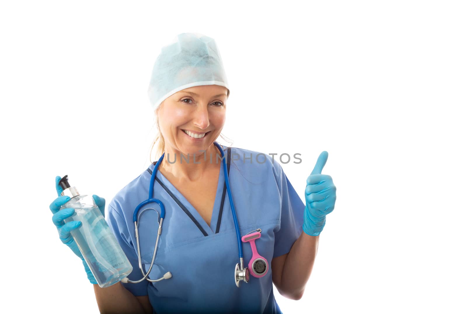 Friendly smiling hospital nurse, or medical professional holding a bottle of hand sanitizer and giving a thumbs up gesture