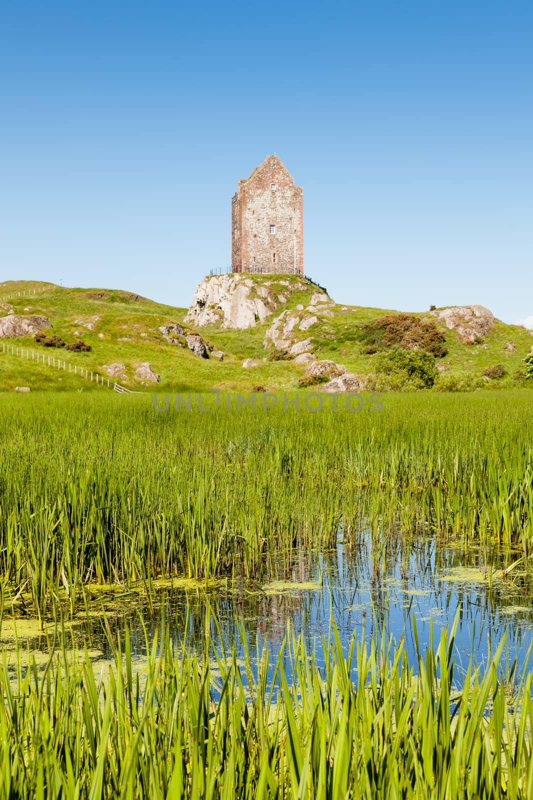 The view across a mill pond towards Smailholm Tower in the Scottish Borders.  The tower was built in the 1400's as protection from border raiders and the elements.