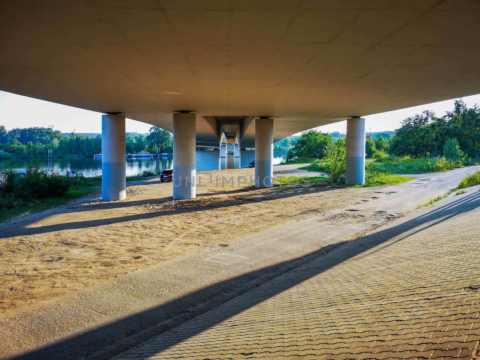 Concrete pillars under bridge on beach near river
